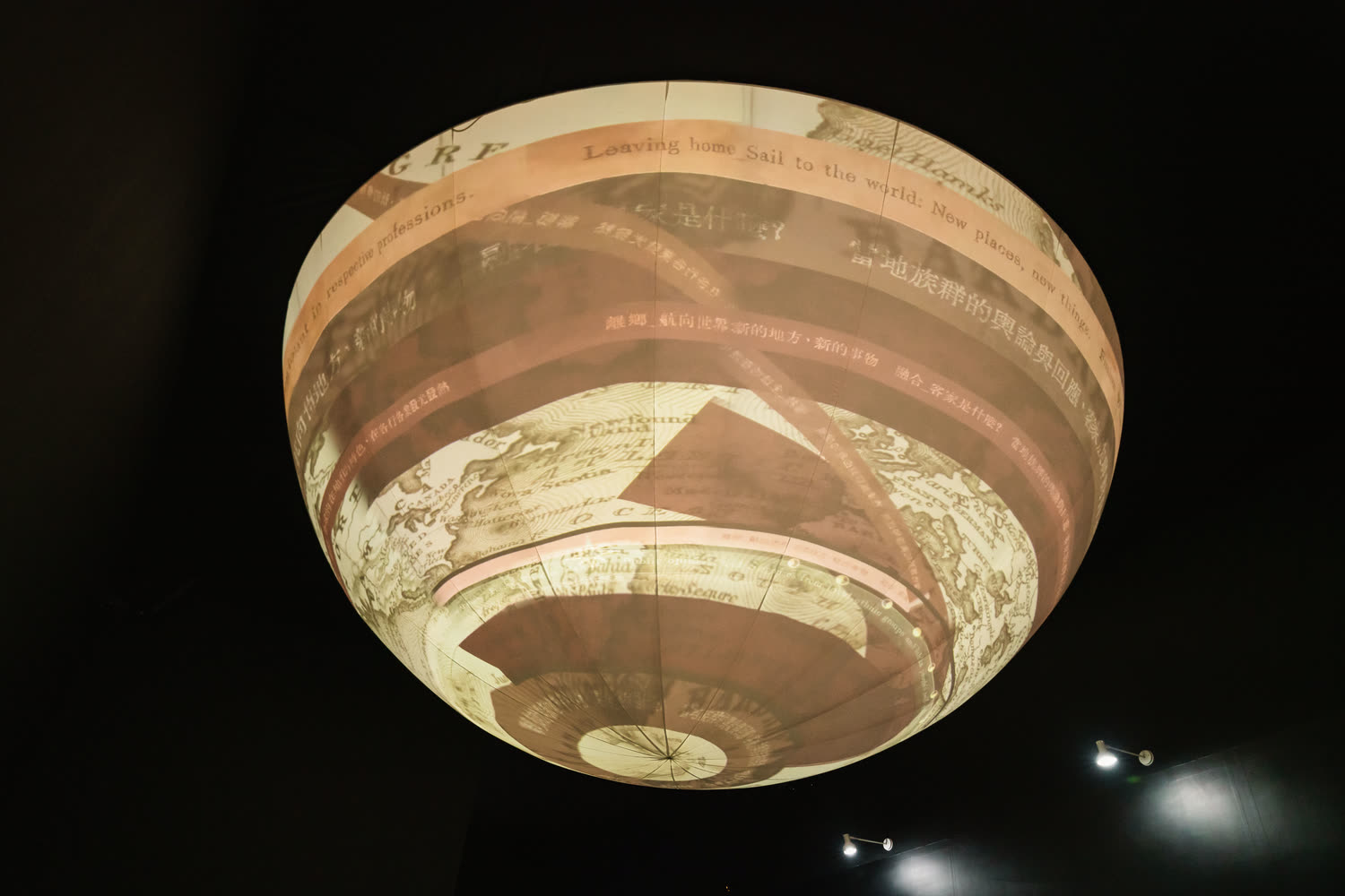 Archival documents and handwriting curving around the sphere in warm brown.