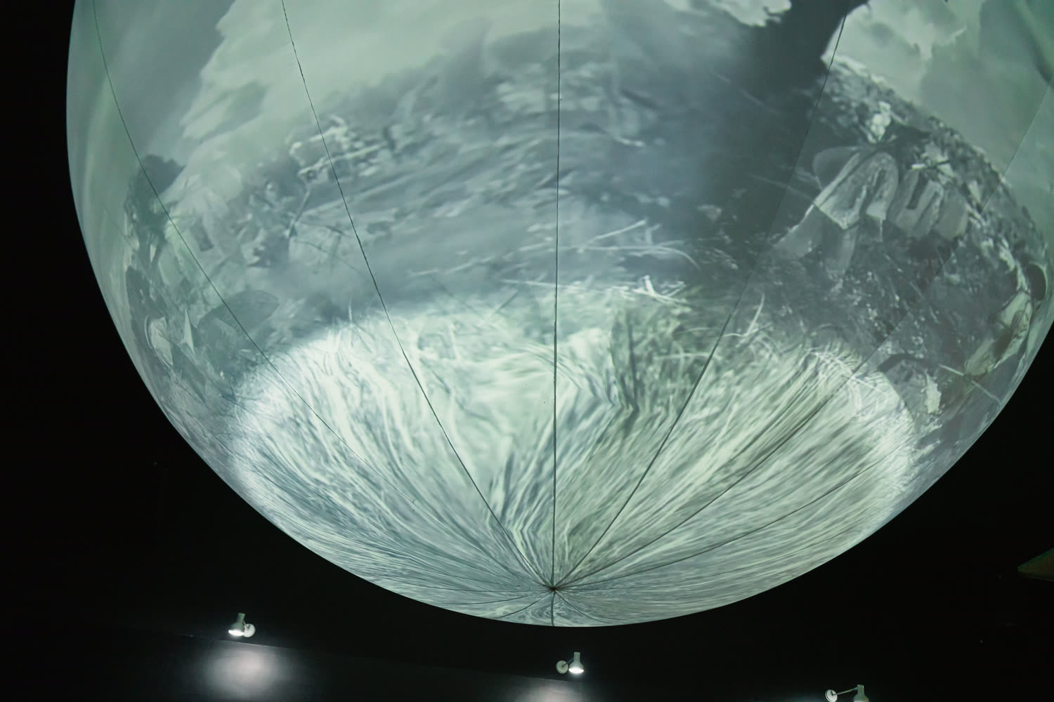 A grey mountain ridge running across the sphere, the light almost monochrome.